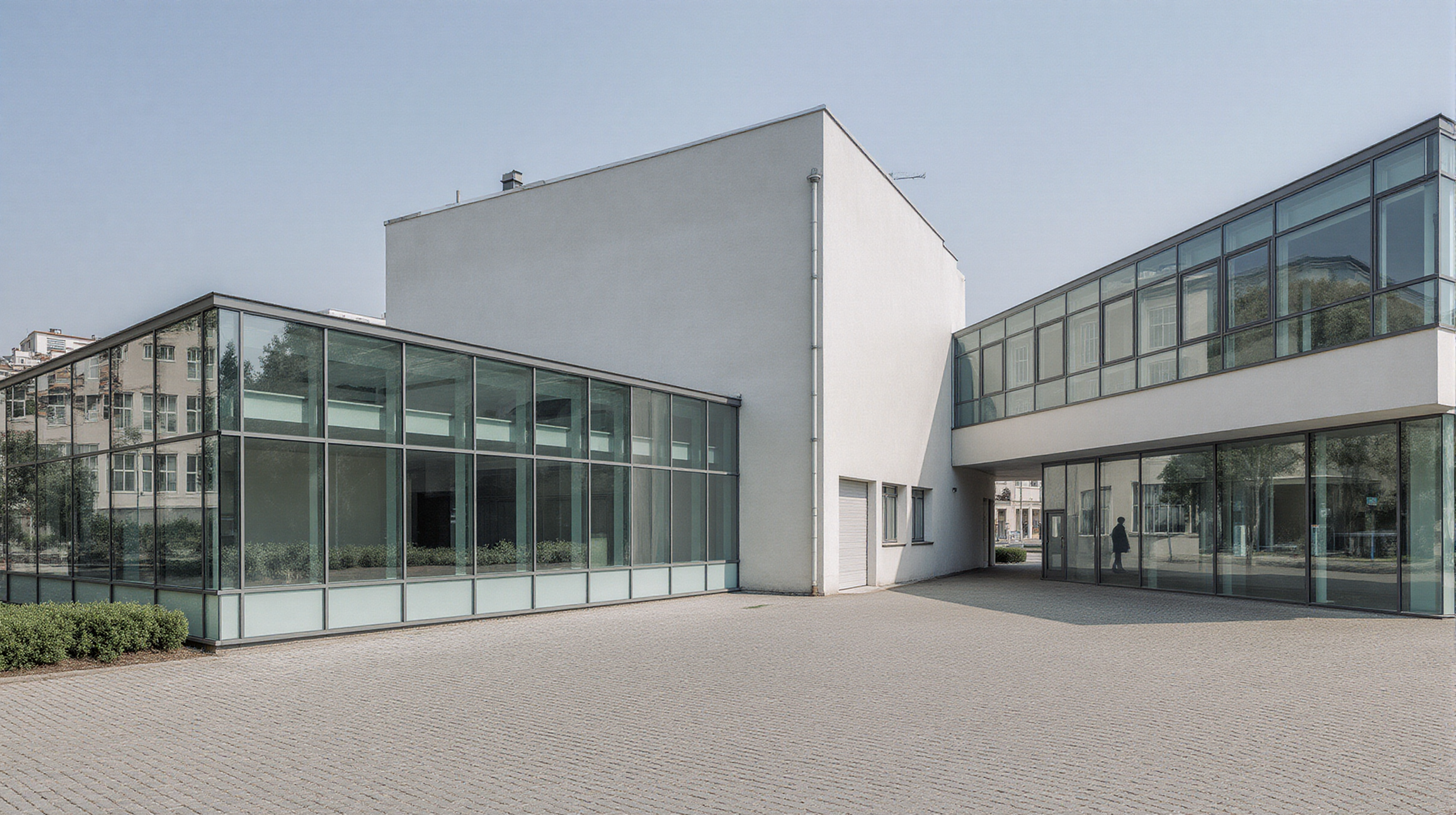 Heller städtischer Gewerbehof mit verglasten Gebäudeflügeln und breiter Zufahrt